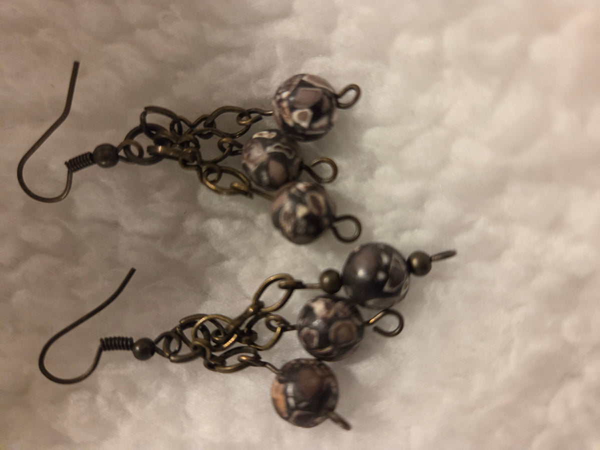 Blanca Closet handcrafted bead earrings with three patterned brown beads and antique bronze chain dangles
