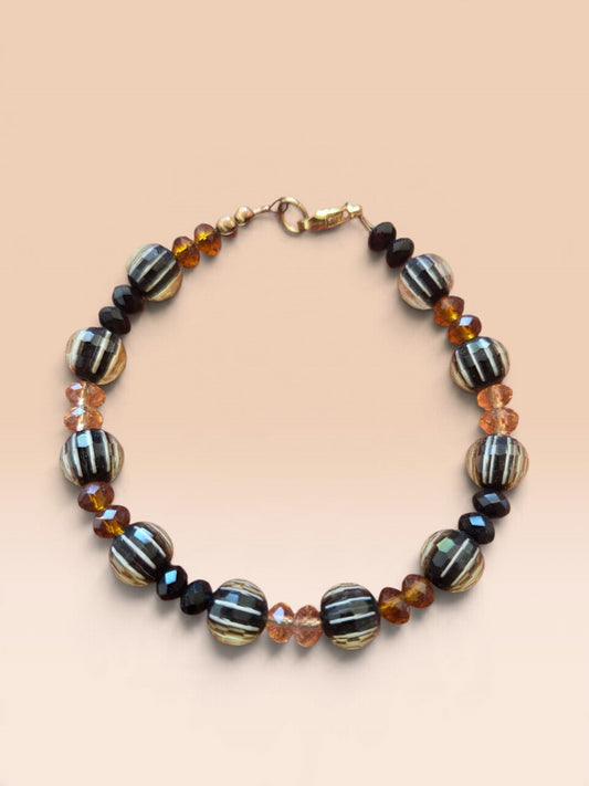 Blanca Closet handcrafted beaded bracelet featuring black and orange striped glass beads with gold-tone clasp
