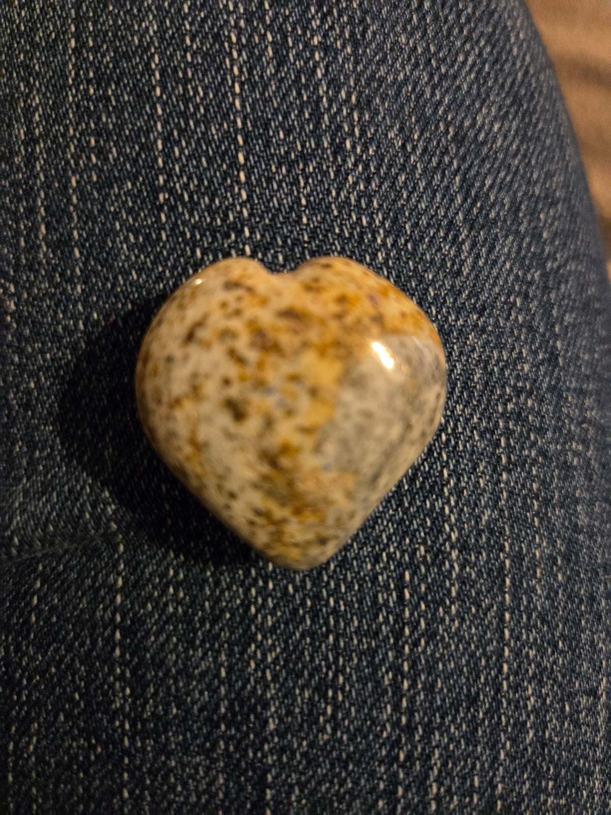 Blanca Closet polished stone heart ornament with earthy brown and cream speckled patterns on blue denim fabric
