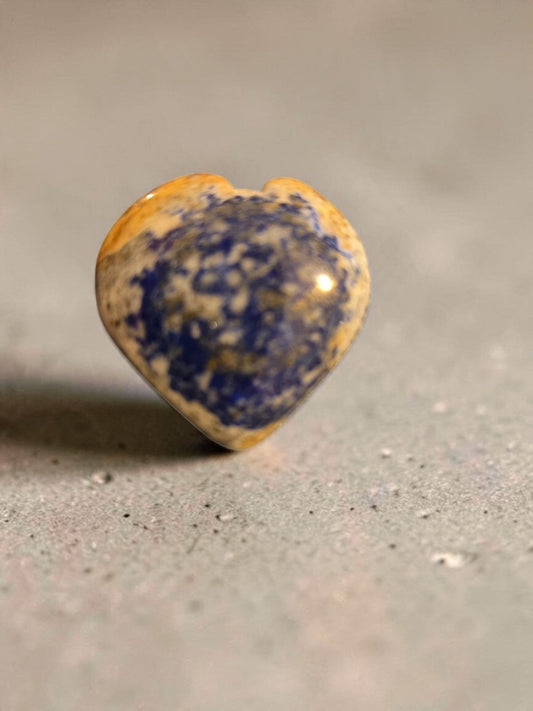 Blanca Closet polished stone heart ornament with blue and tan organic patterns on a textured grey surface