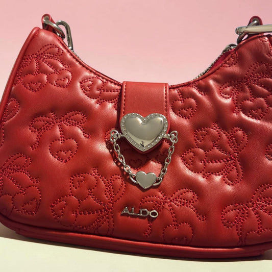 Blanca Closet Aldo red purse with quilted cherry pattern, silver heart charm, and chain detail on a shoulder bag.
